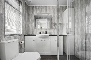 a bathroom with a white toilet and a sink at 7 Bedroom Luxury House sleep 26 in Birmingham +38 photos