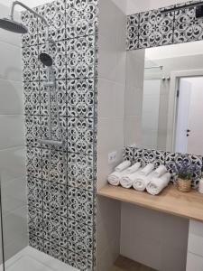 ein Badezimmer mit Dusche und Handtüchern auf einem Regal in der Unterkunft Biały Kruk Apartamenty vis-a-vis Jasnej Góry 2a in Częstochowa + 9 Fotos