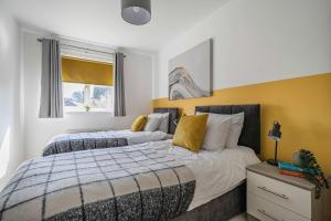 a bedroom with two beds and a window at Stylish 2BR Apartment near MCR Airport in Manchester