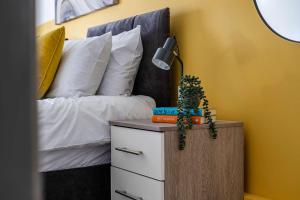 a bedroom with a bed and a table with a lamp at Stylish 2BR Apartment near MCR Airport in Manchester +11 photos