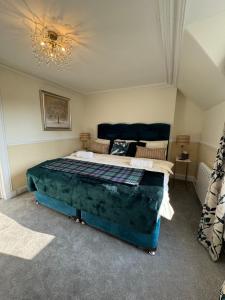 a bedroom with a large bed in a room at Buchan Guest House in Moffat