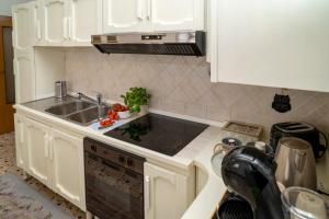 a kitchen with white cabinets and a sink at Sotto la Torre - dimora elegante con vista sulla valle in Caiazzo