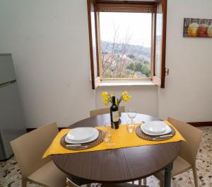 a dining room table with chairs and a window at Sotto la Torre - dimora elegante con vista sulla valle in Caiazzo +29 photos