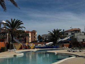 a swimming pool with a water slide in a resort at Mobile home Le Badwill2 in Canet-en-Roussillon +24 photos