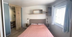 a small room with a bed and a window at Mobile home Le Badwill2 in Canet-en-Roussillon