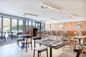 a restaurant with tables and chairs and windows at Parador de Molina de Aragón in Molina de Aragón