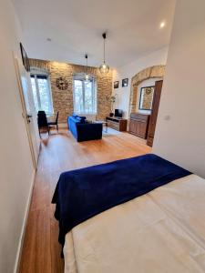 a bedroom with a blue bed and a living room at Biały Kruk Apartamenty vis-a-vis Jasnej Góry 5a in Częstochowa +9 photos