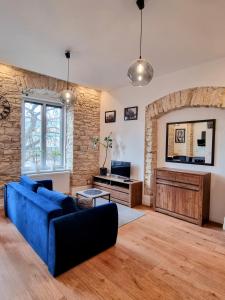 a living room with a blue couch and a tv at Biały Kruk Apartamenty vis-a-vis Jasnej Góry 5a in Częstochowa
