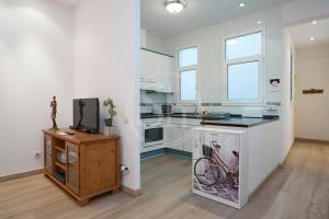 a kitchen with a counter and a tv on a table at Bonito apartamento cerca de Plaza España in Barcelona