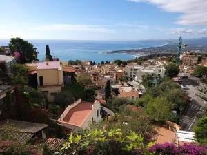 a view of a city with the ocean at La casa nell'aria Casa Scacciapensieri TAORMINA in Taormina