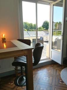 a room with a table and chairs and a large window at Le Canyon Rouen Centre by MyFrenchPAT Terrasse & Parking in Rouen +41 photos