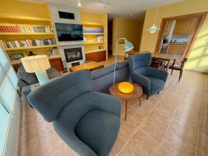a living room with a couch and chairs and a table at Roca de Guía Somiedo in Pola de Somiedo