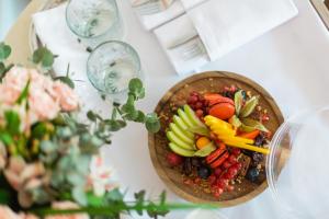 a bowl of fruit on a table with wine glasses at Hospes Amérigo, Alicante, a Member of Design Hotels in Alicante