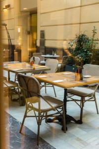 a row of wooden tables and chairs in a restaurant at Hospes Amérigo, Alicante, a Member of Design Hotels in Alicante