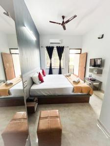 a bedroom with a large bed with a ceiling fan at Golden IB'S Gokarna in Gokarna