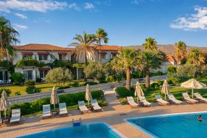 a resort with a pool and chairs and umbrellas at Alaçatı Beach Resort in Yumru