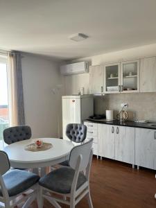 a kitchen with a white table and chairs in a room at Surčin Apartment in Ledine +24 photos