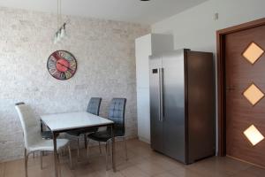 a dining room with a table and a refrigerator at Apartament Warszawska in Kielce
