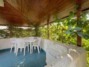 Villa Milly في لينانو سابيادورو: فناء به طاولات بيضاء وكراسي ونباتات