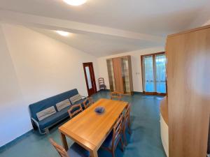 Villa Milly في لينانو سابيادورو: غرفة معيشة مع طاولة وأريكة زرقاء +13 صورة