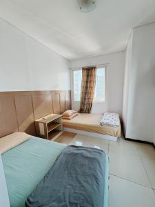 ジャカルタにあるCity Oasis - Staycation in Central Jakartaの小さなベッドルーム(ベッド2台、窓付) +16枚の写真