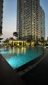 ジャカルタにあるCity Oasis - Staycation in Central Jakartaの高層ビルの前の大型スイミングプール