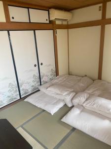 two beds in a room with large windows at 静佳民宿 in Osaka