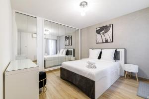 a bedroom with a large white bed and a bathroom at Le Mediterranée-centre-climatisation in Menton