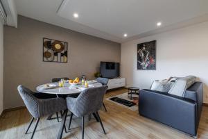 a living room with a table and a couch at Le Mediterranée-centre-climatisation in Menton