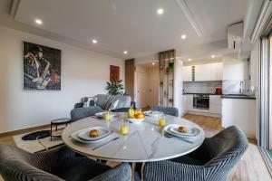 a dining room and living room with a table and chairs at Le Mediterranée-centre-climatisation in Menton