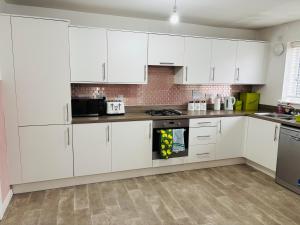 a white kitchen with white cabinets and appliances at Beautiful 3 bed holiday home in Washington, UK in Washington