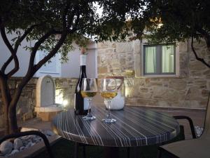 ein Tisch mit zwei Gläsern Wein und einer Flasche in der Unterkunft Marina's Cottage in Lagolíon