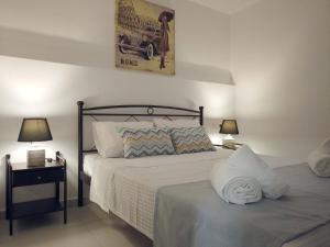 ein Schlafzimmer mit einem Bett und zwei Nachttischen mit Lampen in der Unterkunft Marina's Cottage in Lagolíon + 43 Fotos