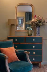 a dresser with a mirror and a chair in a room at My Boudoir in Paris