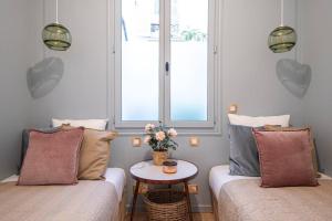 ein Zimmer mit zwei Betten und einem Tisch mit Blumen in der Unterkunft My Cottage in Paris in Paris