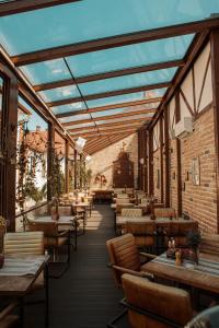Un restaurante con mesas y sillas de madera y una pared de ladrillos. en Casa Nicolae Luxury Suites, en Sibiu