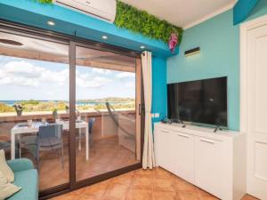 sala de estar con puerta corredera de cristal y comedor con mesa en True paradise with a splendid panoramic terrace, en Porto Rotondo