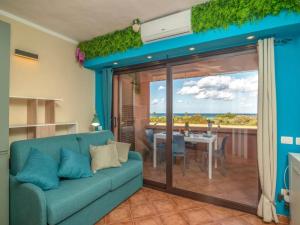 sala de estar con sofá azul y mesa de comedor en True paradise with a splendid panoramic terrace, en Porto Rotondo