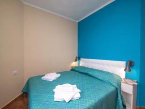 1 dormitorio con 1 cama verde y 2 toallas en True paradise with a splendid panoramic terrace, en Porto Rotondo