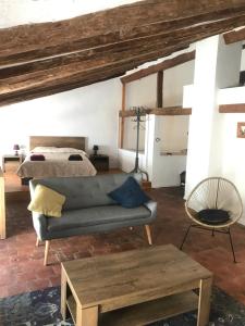 a living room with a couch and a bed at Spacious attic apartment in Perelló +18 photos