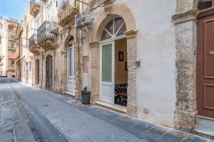 an empty street with a white door on a building at Gargallo Loft in Ortigia in Siracusa