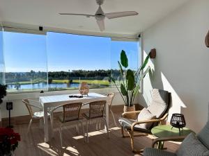 a dining room with a table and chairs and a large window at Mar de Astrid Apartamentos Playa Granada in Motril