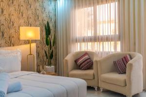 a bedroom with a bed and two chairs and a window at Hotel Rias Dakhla & Restaurant in Dakhla