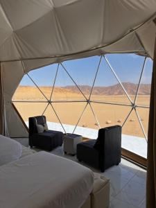 a tent with two beds and a view of the desert at Wadi rum Ali camp in Wadi Rum