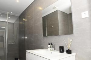 een badkamer met een wastafel en een spiegel bij MyHome Braga1 in Braga