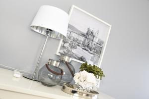 een tafel met een lamp en een vaas met bloemen bij MyHome Braga1 in Braga