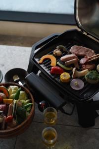 a grill with meat and vegetables and a basket of food at AO NAKIJIN yanbaru terrace in Nakijin +10 photos
