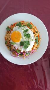 a plate of food with an egg on top of pasta at Horizon Palace - Kabalana in Ahangama