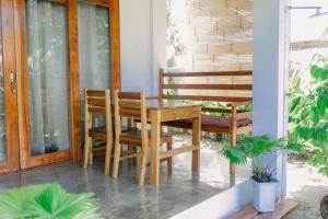 a wooden table and chairs on a porch at Villa De Mikaël in General Luna