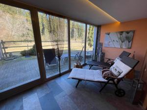 a room with sliding glass doors and a chair and a patio at Landhotel Karin in Freudenstadt